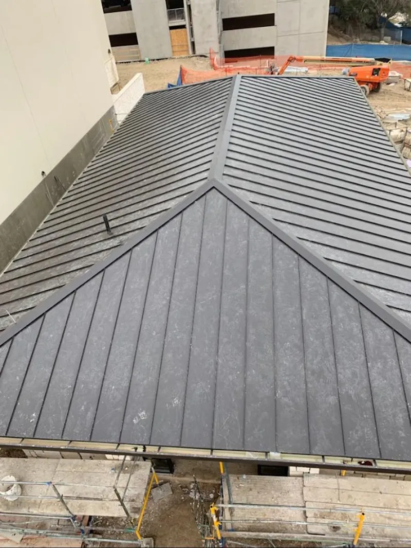 Commercial metal roof construction with crane equipment in Canfield